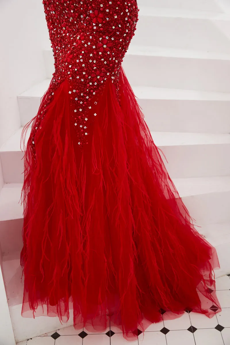 Splendid red mermaid ceremony dress with jewel embellishments and feather skirt.