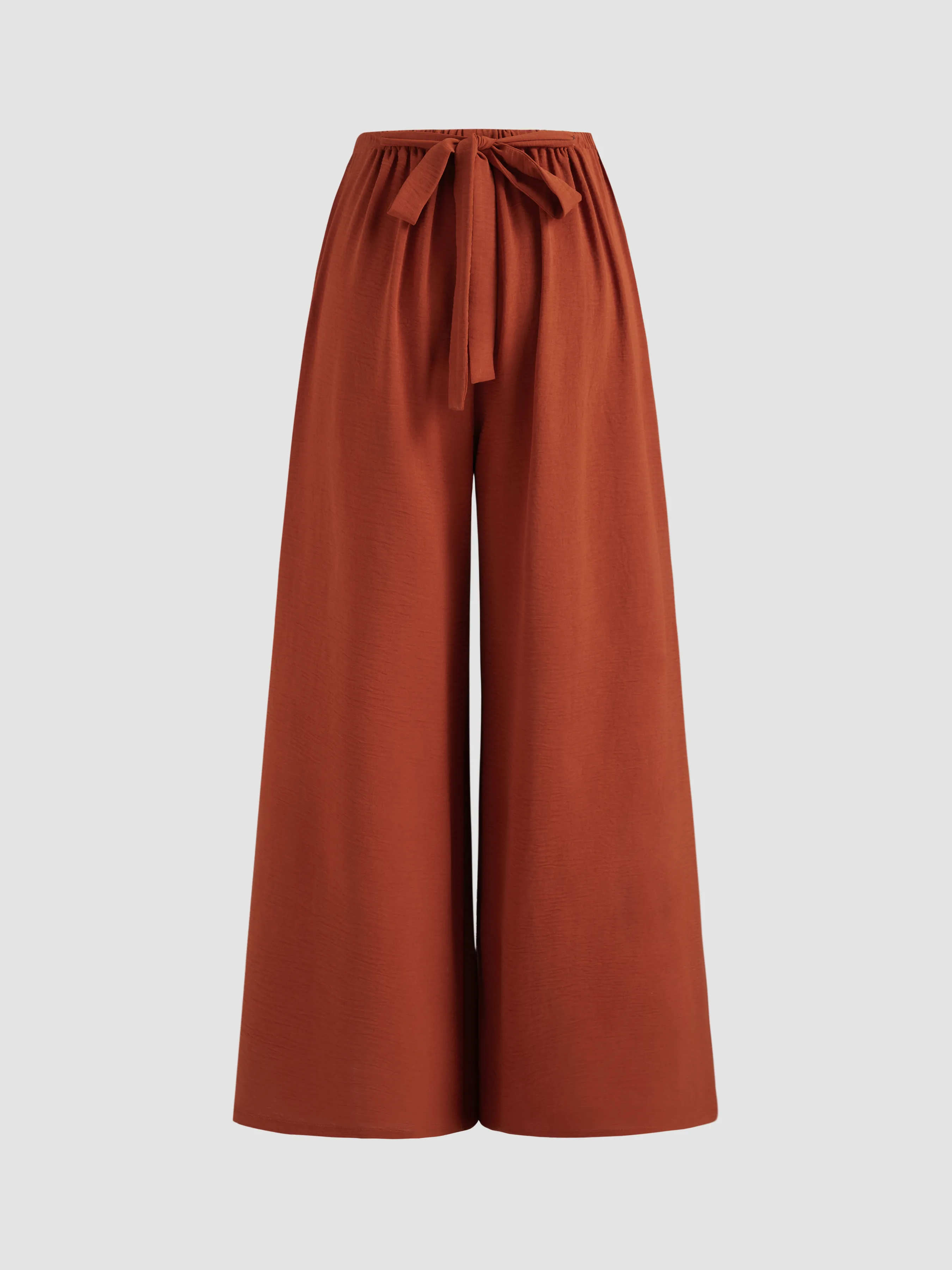 Wide-leg jumpsuit with tied waist and reversible V-neck in solid color.